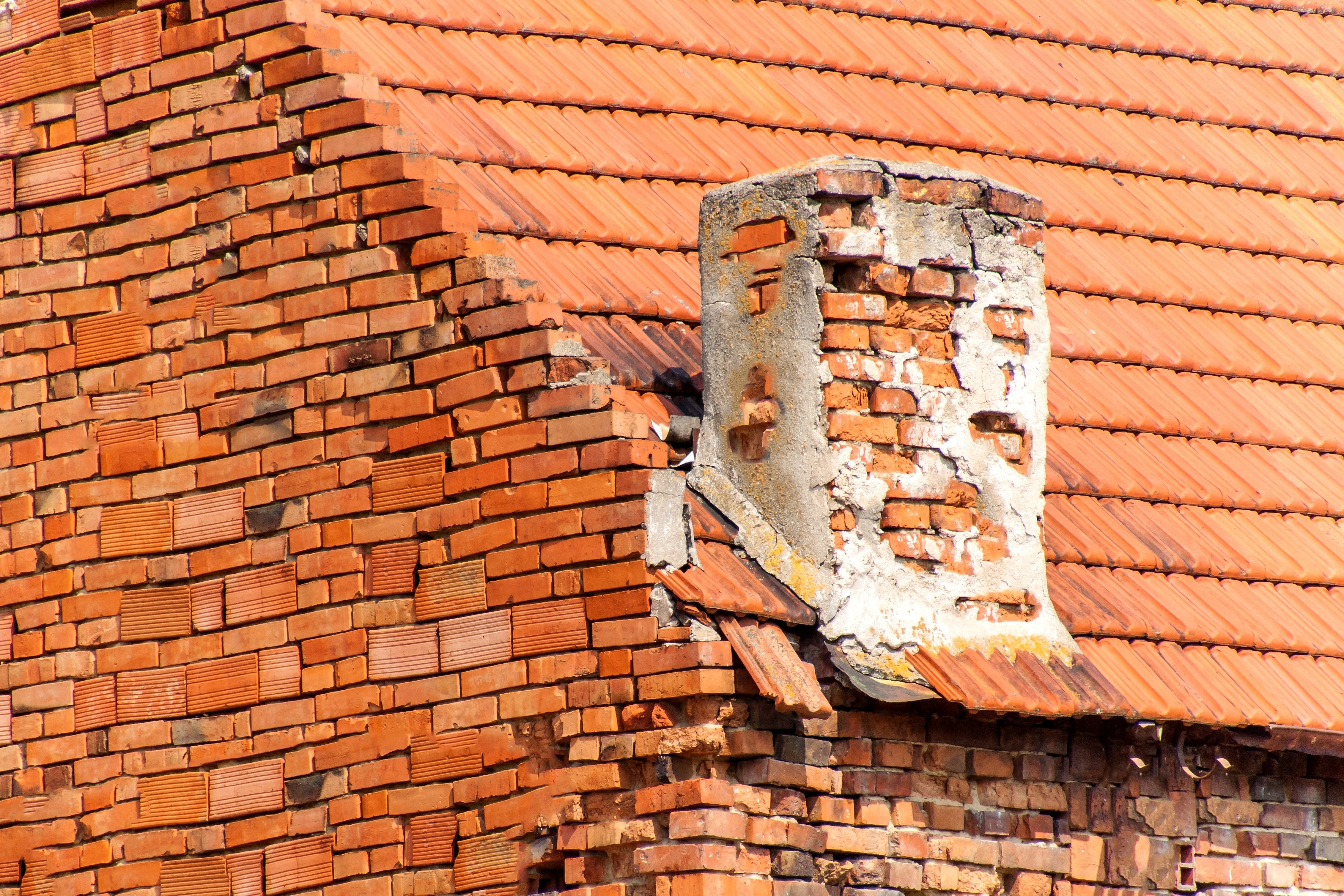 Old brick chimney on the roof. brick masonry. damaged chimney.
